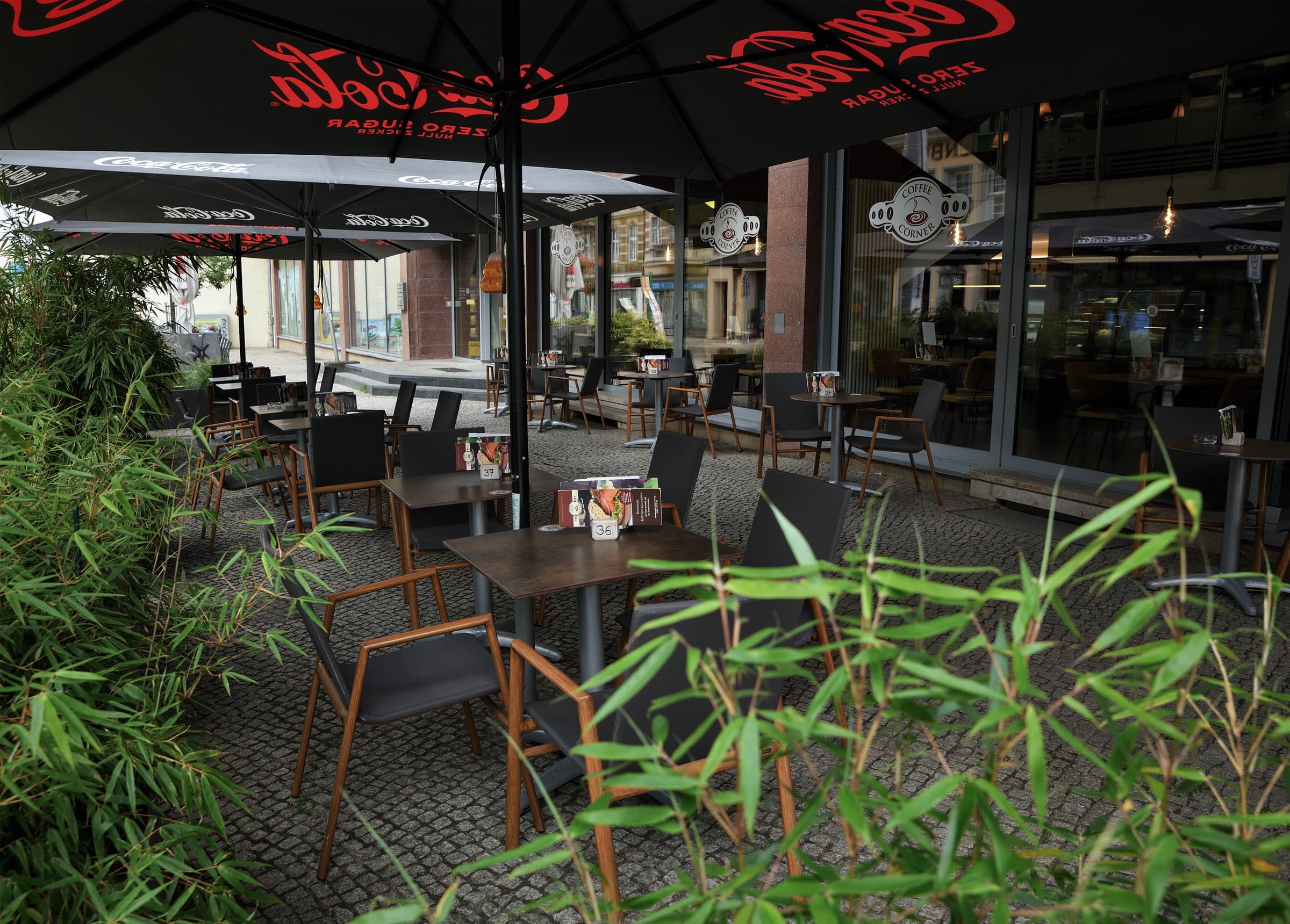 Die Terrasse des Coffee Corner mit Sitzplätzen und Sonnenschirmen